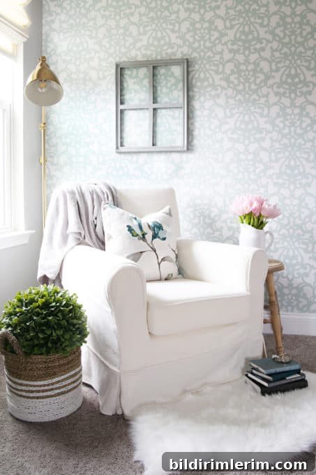 Modern Farmhouse Bloggers to Follow for Home Design 7 cozy white chair sitting in a corner with a lamp behind and a stand with pink flowers on the side
