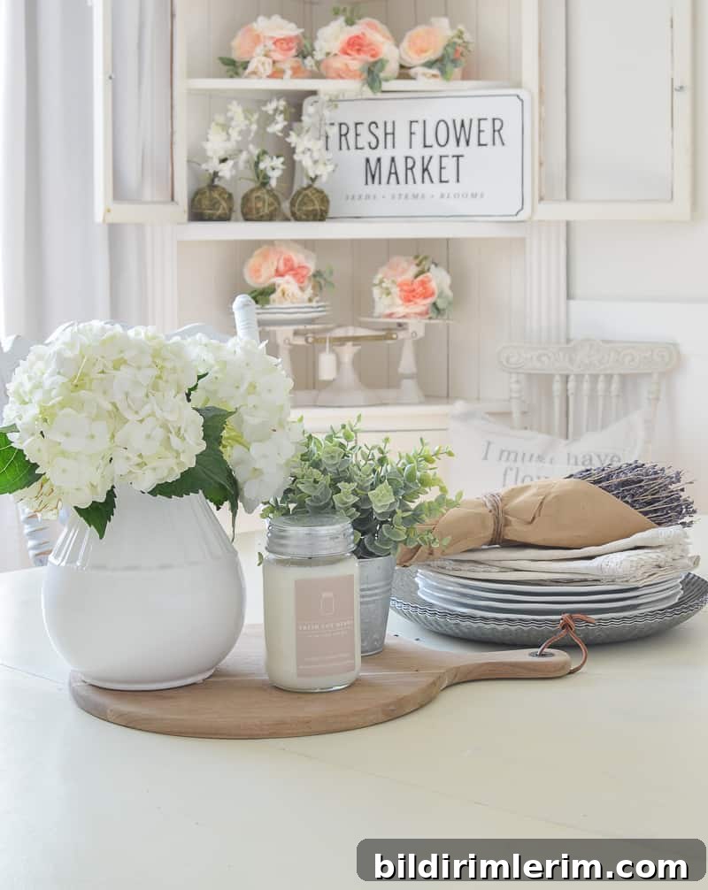 Modern Farmhouse Bloggers to Follow for Home Design 9 White Dining Room table with a flower centerpiece on it and a hutch in the background with coral flowers