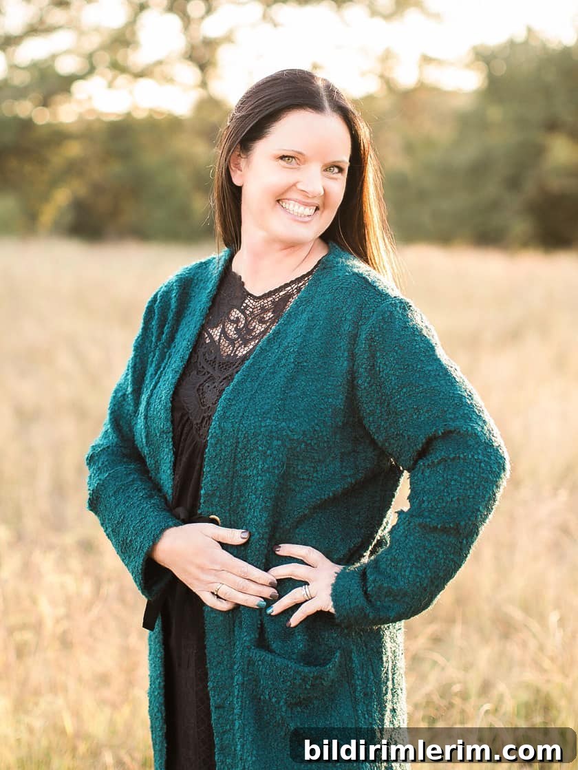 picture of smiling lady with dark hair standing in a field