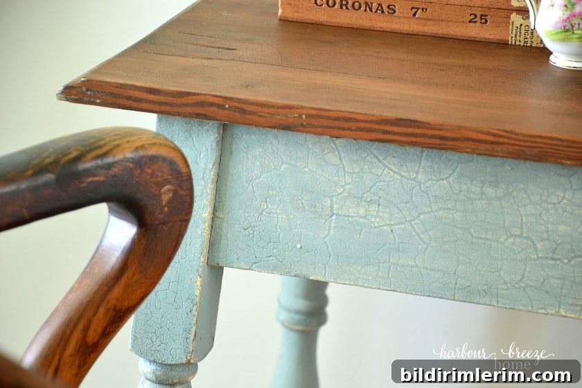 a wood stained table top with blue crackle finish on the legs and apron