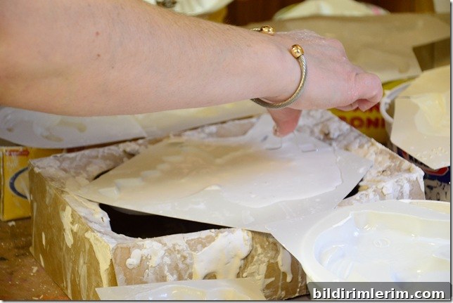 adding a bent wire hanger into the liquid plaster of paris on the back of the mould before the mixture hardens.