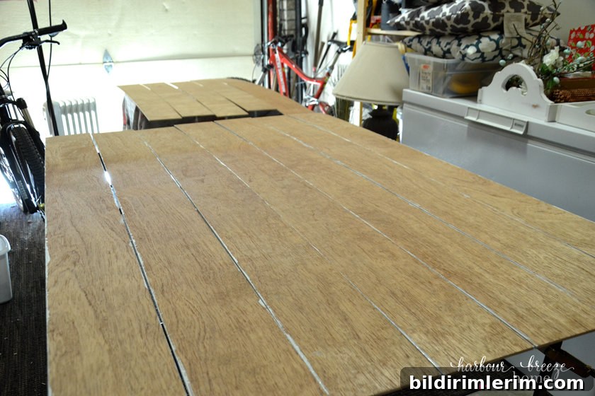 Plywood boards that will be used for DIY Shiplap Wall laid out to be painted.