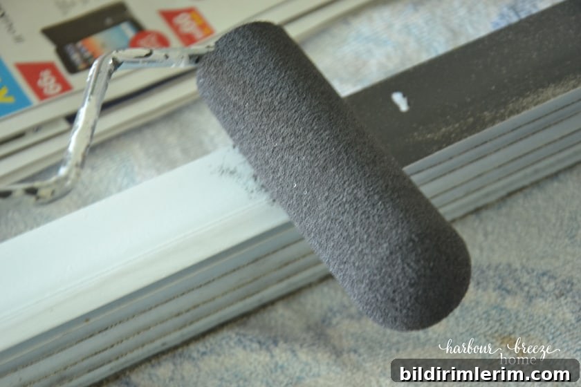 How to paint vinyl door sweeps a custom color a foam roller painting a dark gray color on a vinyl door sweep