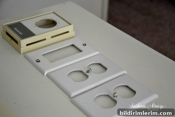 Light switch covers and screws lined up on a shelf