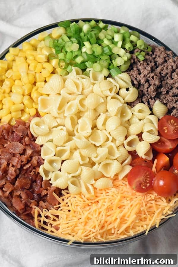 Pasta salad ingredients in a bowl ready to stir