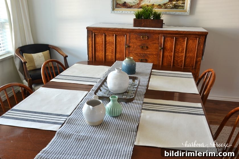 4 placemats with gray stripes sitting on a wooden table with a gray checked runner down the center