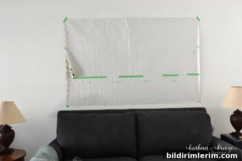 The gallery wall template paper taped above the wall above a couch