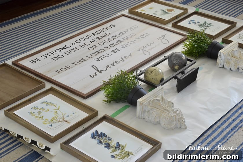 Wall decor items laid out on the gallery wall template paper on the floor in an arrangement.