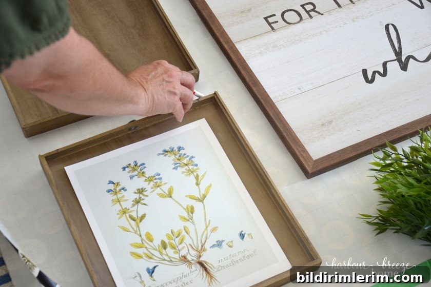a lady marking the top of a picture on a gallery wall template with a pen