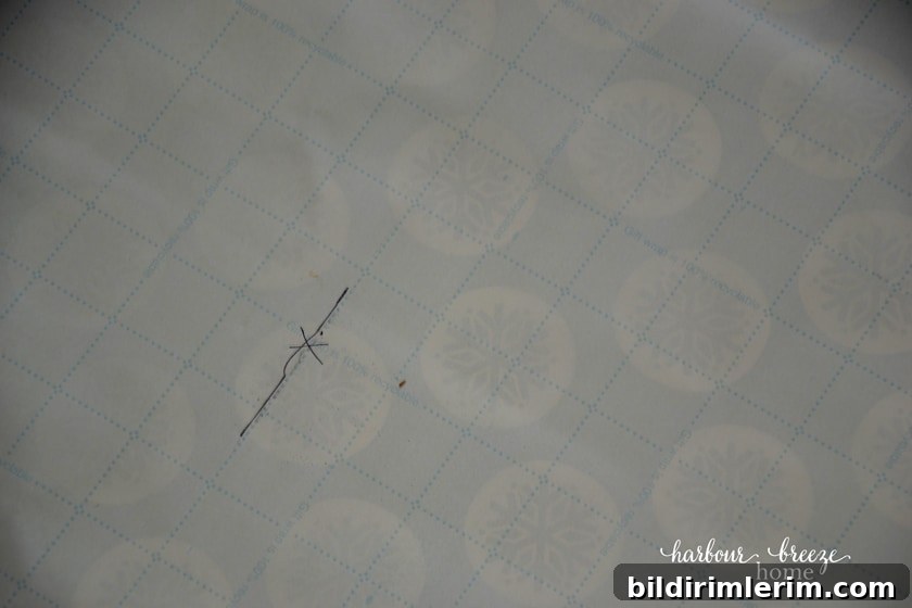 an "x" marked on the gallery wall template where a nail needs to go for proper picture placement