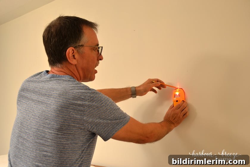 Using a stud finder on the wall