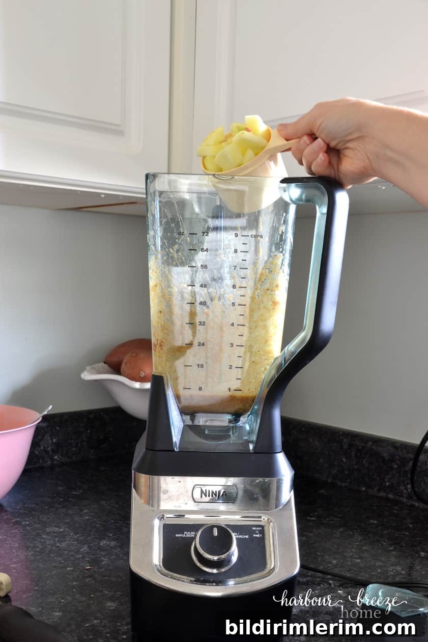 Pouring apple chunks into a blender