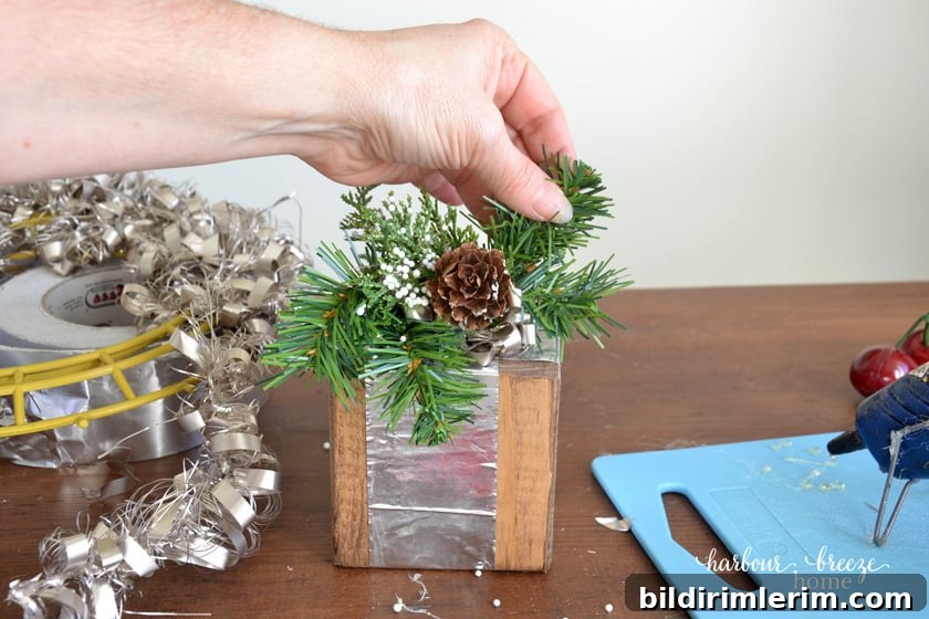 adding faux greenery to a wooden block gift
