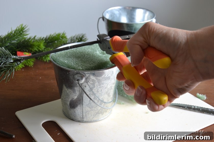 DIY Mini Flocked Christmas Tree Tutorial 5 using wire cutters to cut faux branches for a christmas tree mini