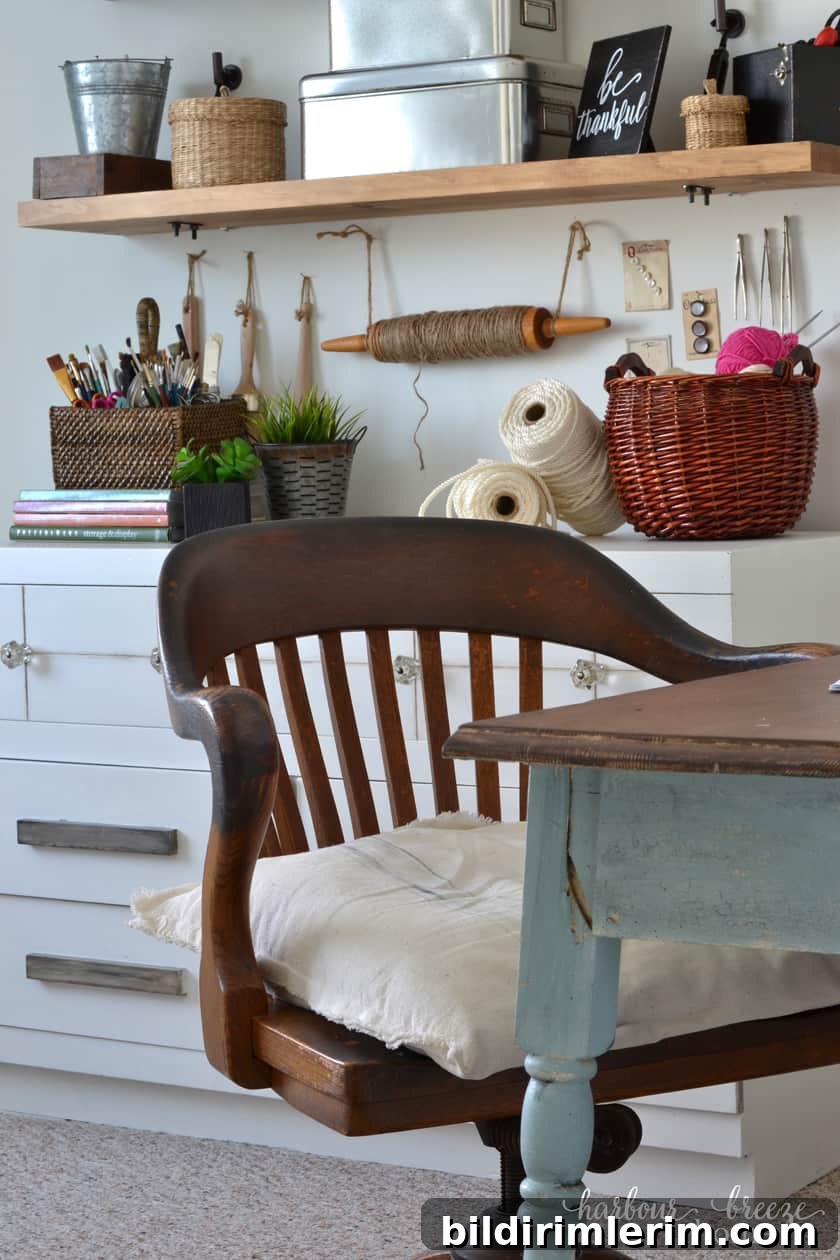 Antique Wooden Desk Chair at a farmhouse table with a wall of shelves with craft supplies in the background.
