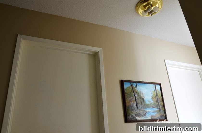 hallway with builder basic trim and a broken ceiling light