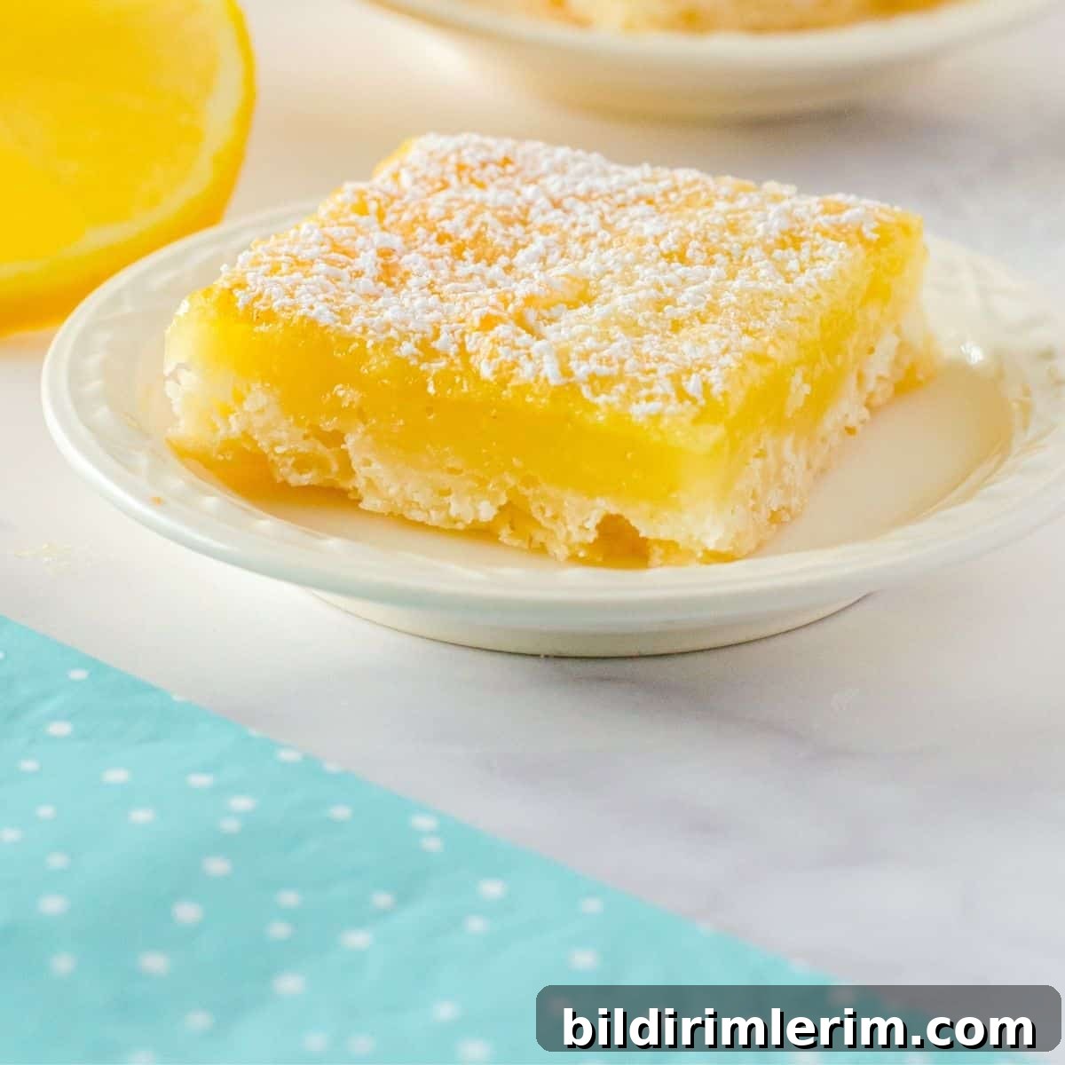 A lemon square sitting on a plate