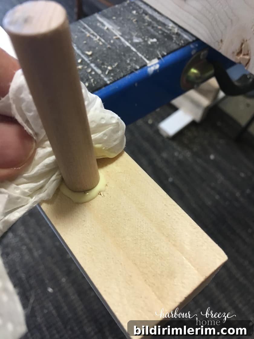 how to make a diy floating shelves - Gluing in the dowel pieces with wood glue and wiping off the excess glue.