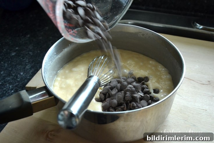 Foolproof Homemade Chocolate Fudge Recipe 5 Pouring chocolate chips into chocolate fudge heated ingredients