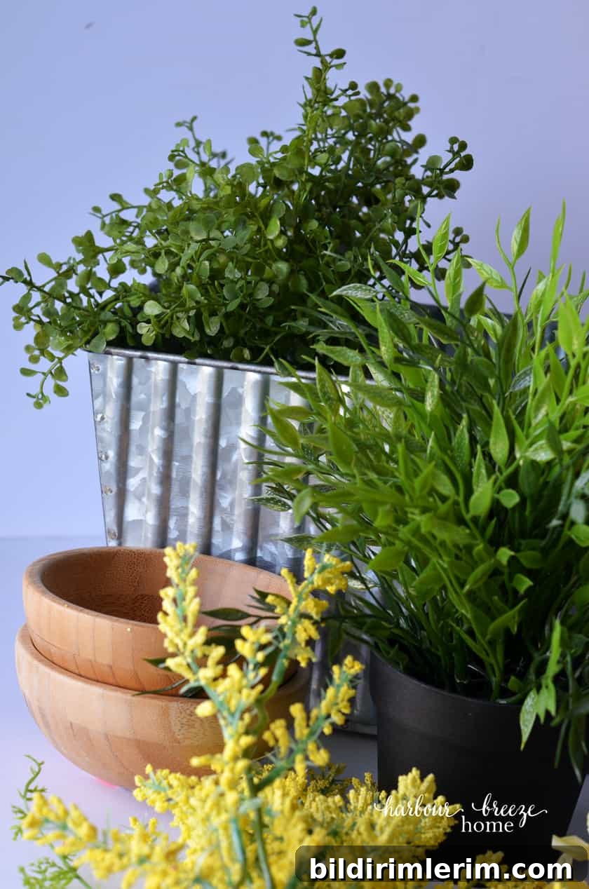 The supplies for this quick and simple DIY farmhouse centerpiece are an assortment of faux greenery and yellow flowers, along with a galvanized metal flower box.