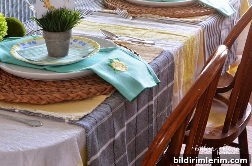 Layer the table with a yellow striped tablecloth, plaid dishtowels under the placesetting, and stacked plates on a woven charger.
