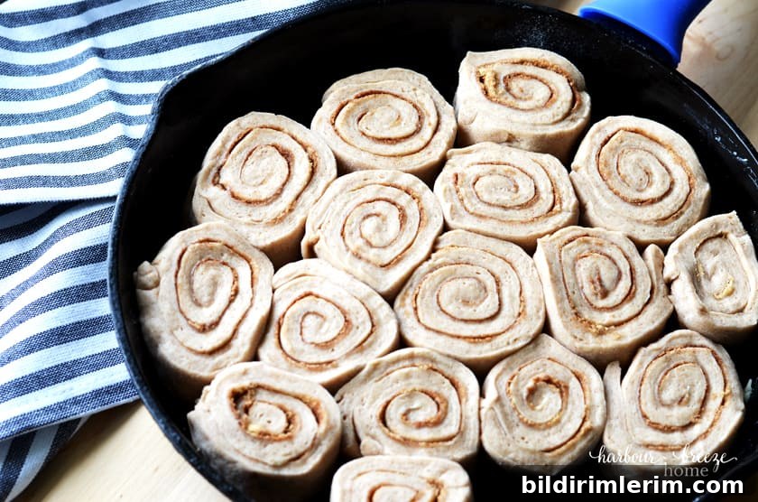 Cast Iron Skillet Cinnamon Rolls with Caramel Glaze 4 Caramel cinnamon rolls in dough form arranged in a cast iron skillet
