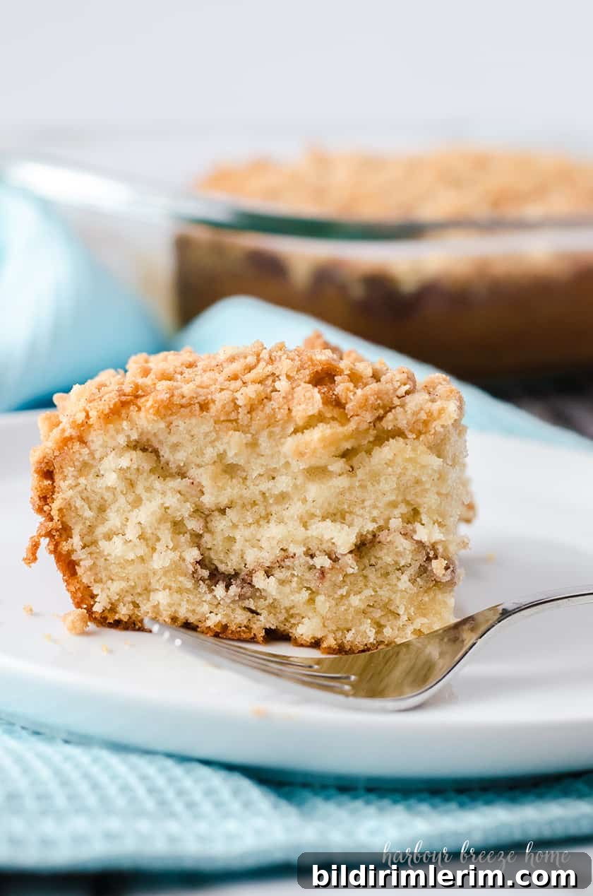 Copycat Starbucks Coffee Cake Recipe to Make at Home 6 Slice of coffee cake on a plate next to a cup of coffee.