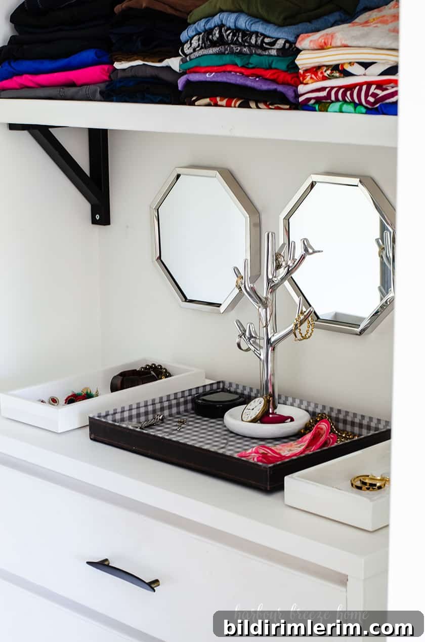 Jewelry in trays on top of a dresser in a small closet.
