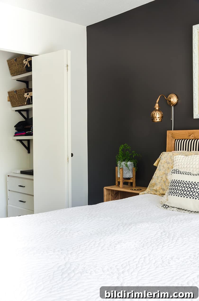 A small closet in the side wall of a Master bedroom with the door open.