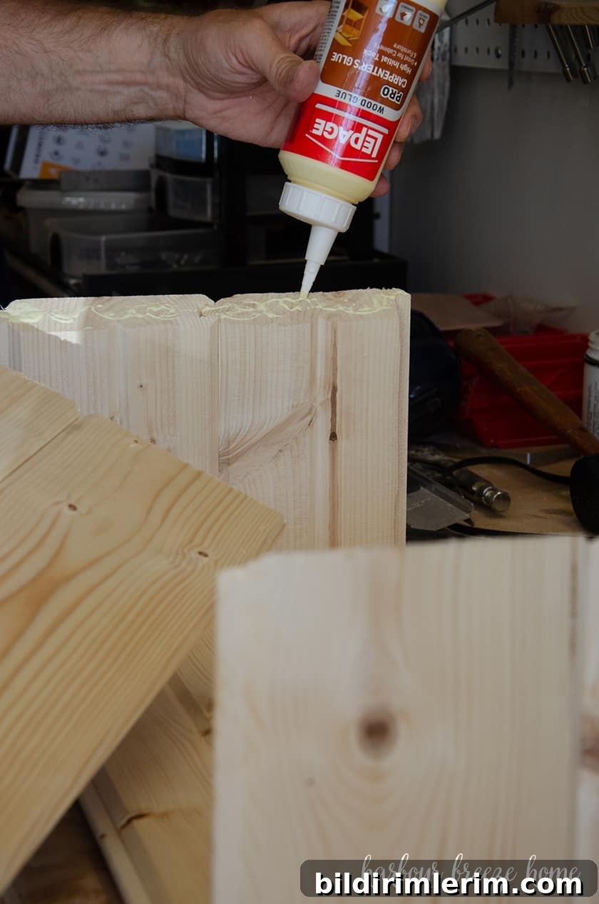 Glue being squeezed on to the corners of the wood where the top of bedside table will be attached.