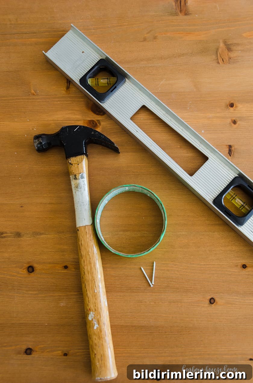 Hang a Picture on Drywall with Two Hooks: Step-by-Step Guide 3 Hammer, painter's tape, nails and level - supplies needed to hang a picture with two sawtooth hangers in drywall.