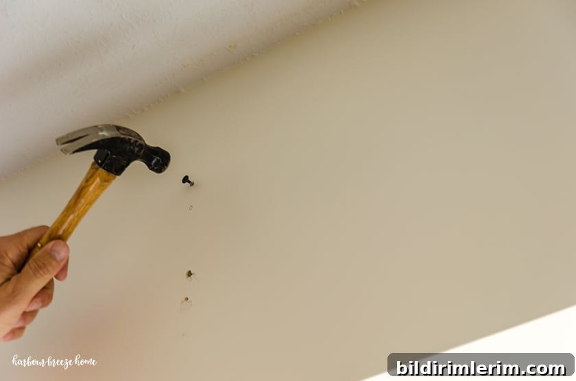 Using a nail to mark where a curtain rod bracket should go.