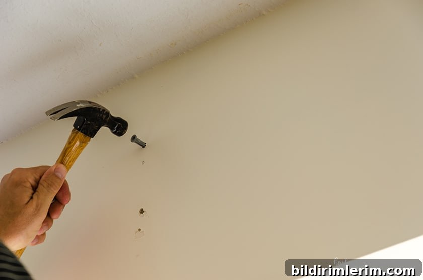 Hammering in a wall anchor to attach a curtain rod bracket
