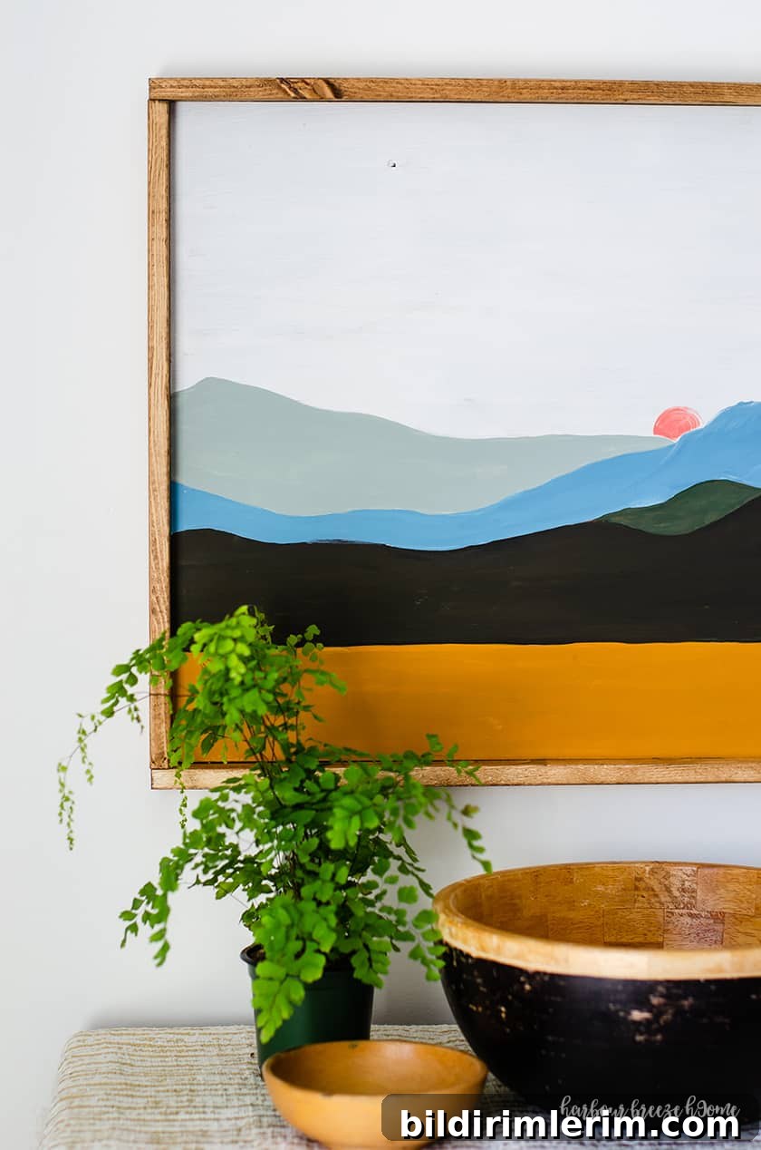 a boho landscape painting of a mountain scene with a simple wood frame around it