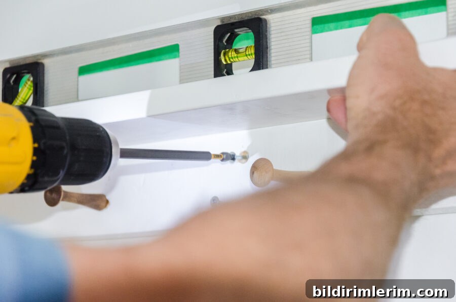 using a drill with a screwdriver attachment to hang a boho shelf on the wall