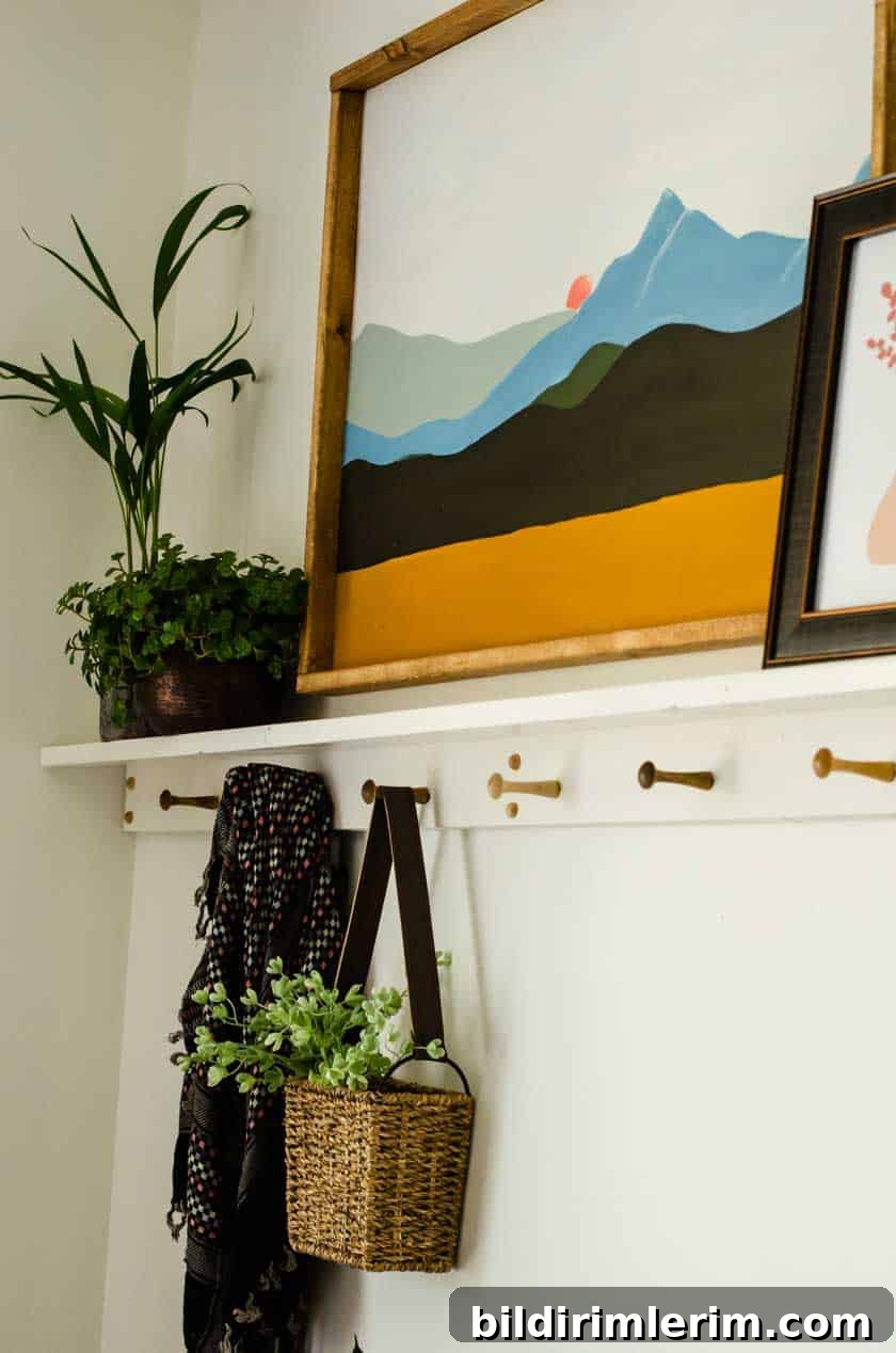 A basket with a handle hanging on one of the pegs of a boho shelf with peg rail underneath.