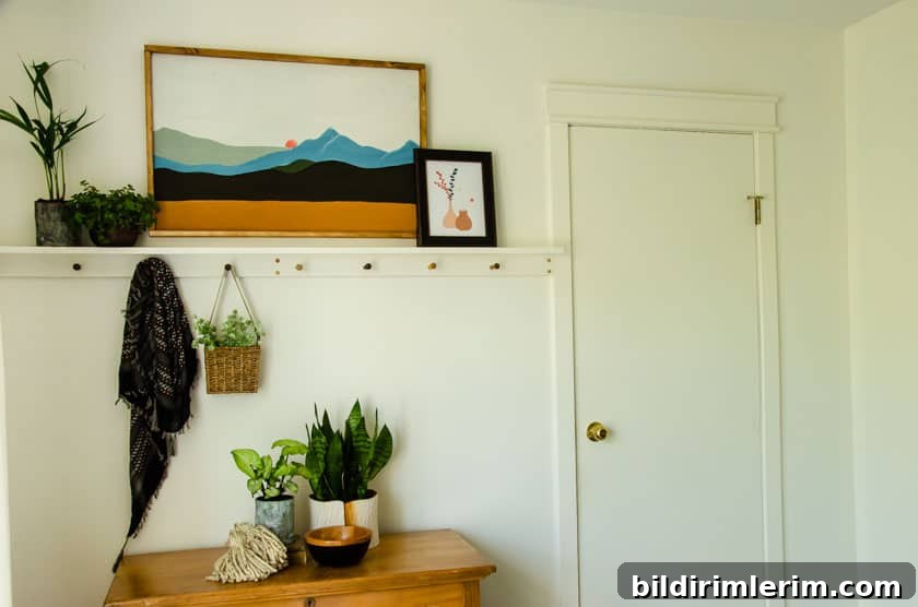 A boho shelf  with peds styled with boho art above it, a dresser below it, and a door leading to a bathroom beside it.