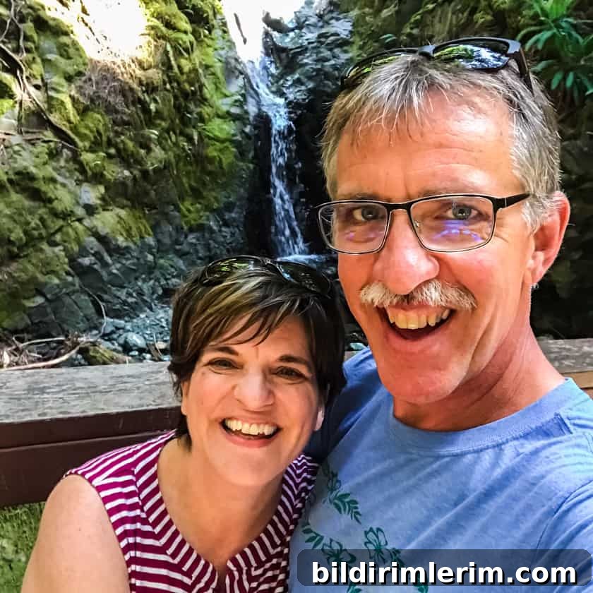 A couple standing in front of a waterfall on Vancouver Island, BC Canada.
