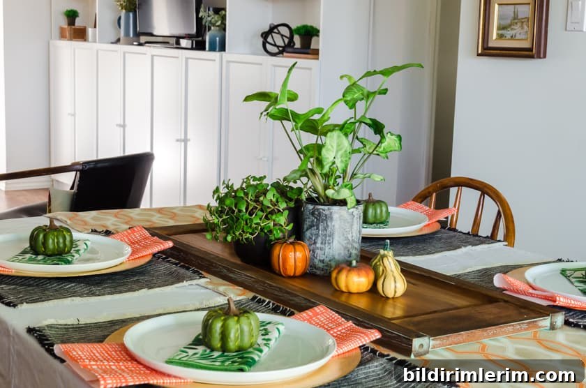 Table set in fall colors in a dining room with the open concept living room in the background