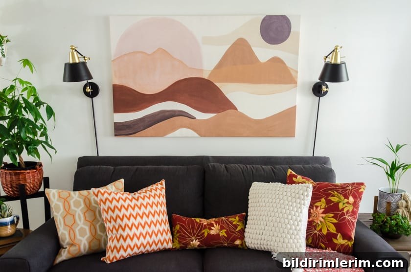 Gray Lazboy couch with boho style landscape art above it.