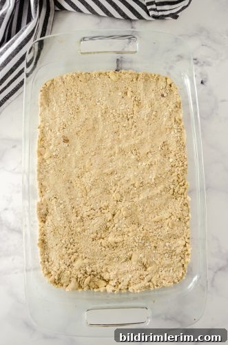 Homemade Rhubarb Crisp Recipe with Buttery Oat Topping 6 Rhubarb Crisp topping patted onto the rhubarb in baking dish.