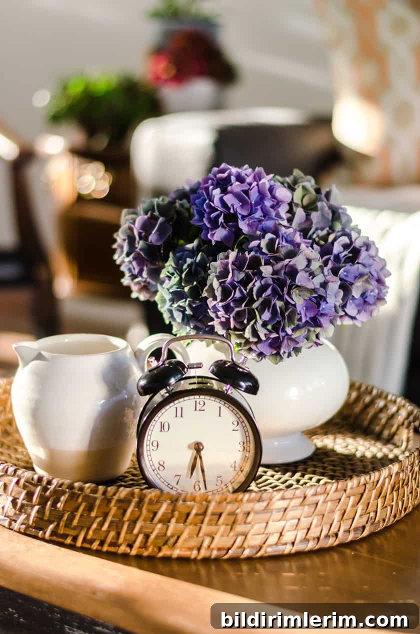 Coffee table decor perfect for Fall with a farmhouse boho look - a vase of flowers, stoneware pitcher, and vintage look clock.