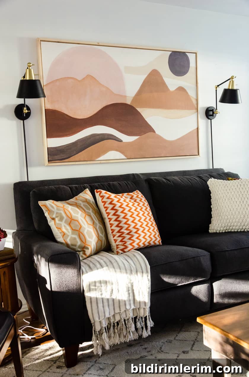 Adding a striped blanket draped on a gray Lazy-boy couch with fall colored throw pillows - an easy room decor idea for Fall!