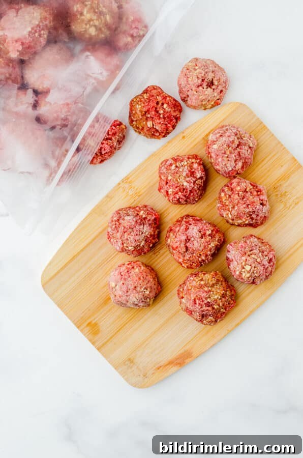 Frozen meatballs spilling out of a zip-top freezer bag