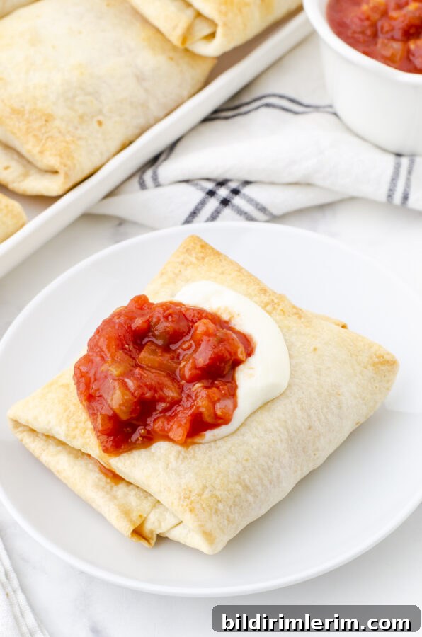 Crispy Baked Chicken Chimichangas 2 Chicken chimichanga on a plate with salsa and sour cream