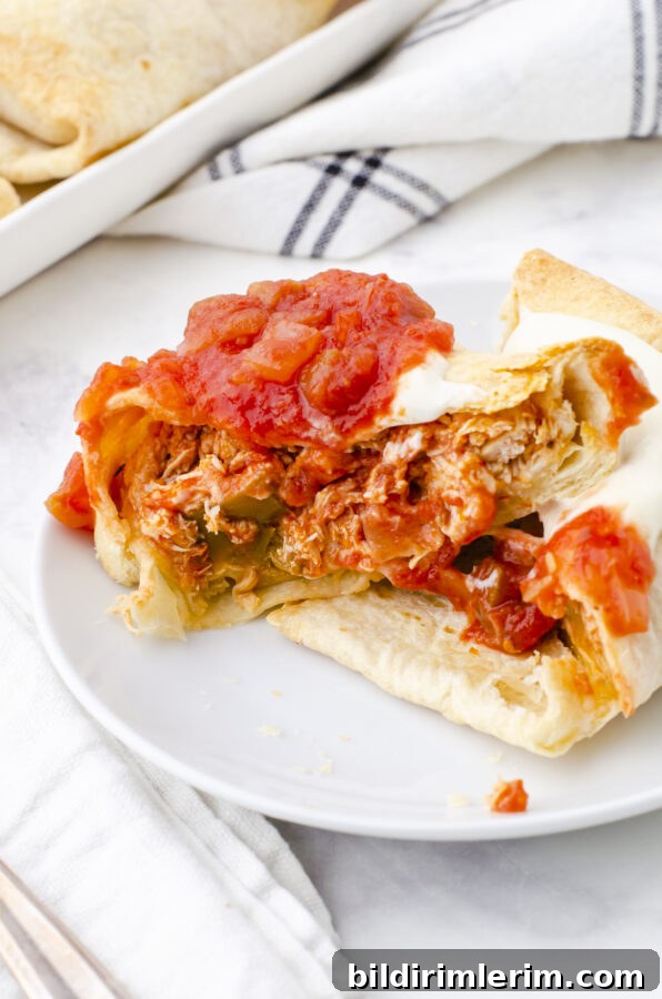 Crispy Baked Chicken Chimichangas 5 A chicken chimichanga cut in half to show the shredded chicken and cheese filling.