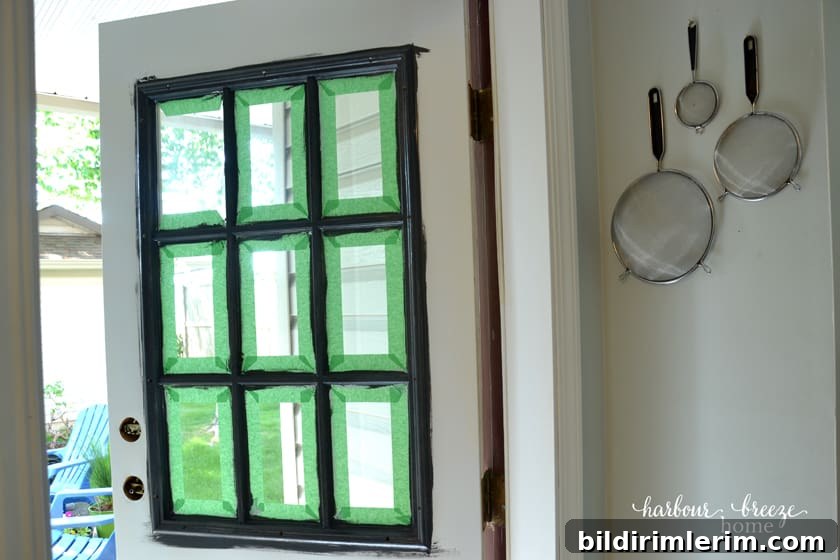 Front door with painters tape around the window panes.