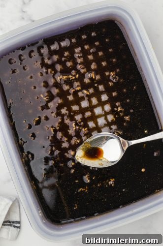 chicken teriyaki marinade being stirred in a tupperware marinade container