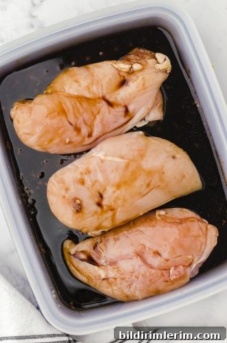 Chicken breasts sitting in teriyaki chicken marinade