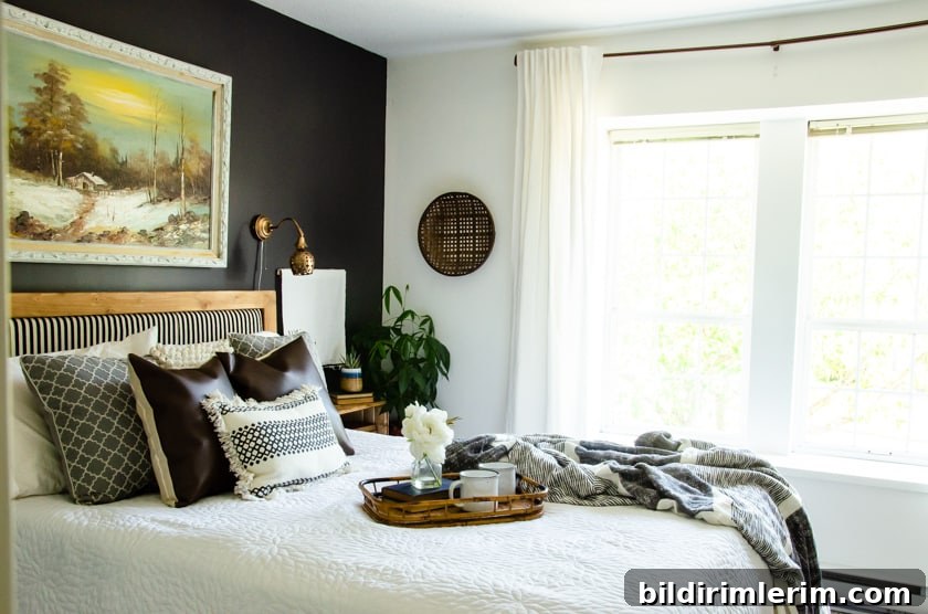 Master bedroom with a bed against a dark painted wall and light colored wall with window beside it. This picture doesn't have the sconce wires hidden yet!